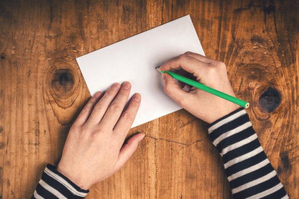 Image Of Girl Writing On A Blank Card At Her Desk - Search Influence